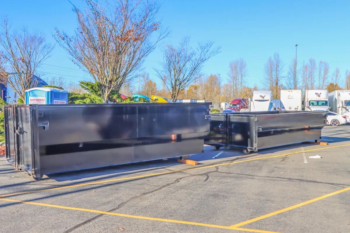 Professional dumpster rental service with roll-off container on residential driveway in Newman